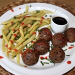 klopsiki z tofu wędzonego podane na talerzu z gotowaną fasolką szparagową oraz sosem sojowym z wasabi