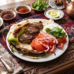 kofte kotleciki tureckie z mięsa mielonego podane na talerzu z lawaszem i warzywami