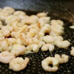 na patelni smażą się obrane krewetki koktajlowe