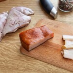 kawałek słoniny i udka z królika na blacie kuchennym