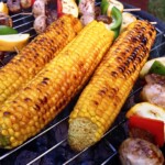 trzy kolby kukurydzy pieką się na grillu