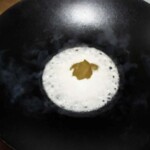 na patelni gotuje się mleczko kokosowe z zieloną pasta curry