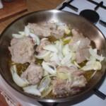 na patelni smażą się kawałki jagnięciny razem z cebulą