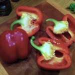 dwie czerwone papryki przekrojone na połowę