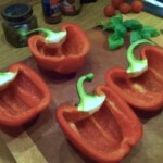 dwie czerwone papryki przekrojone na połowę i oczyszczone z nasion