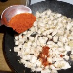 na patelni smaży się kurczak pokrojony w niedużą kostkę