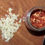 słoik z płatkami chilli i siekany czosnek na desce kuchennej