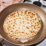 piadina romagnola wypełniona składnikami podgrzewa się na patelni