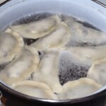 pierogi z borówkami gotują się w garnku w wodzi e