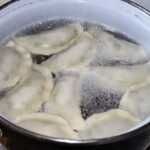 Pierogi z borówkami gotują się w dużym garnku