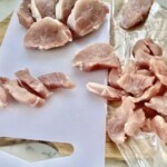 polędwiczka wieprzowa pokrojona leży na desce kuchennej