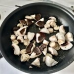 na patelni smażą się pokrojone drobno pieczarki