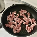 na patelni smażą się małe kawałki polędwiczki wieprzowej