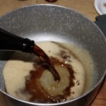 wlewanie ciemnego wina do garnka