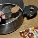 łyżeczka cynamonu dodawana do sosu w garnku