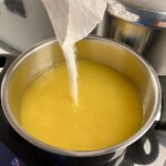 wsypywanie cukru do soku pomarańczowego w garnku