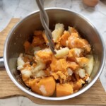 w garnku miażdżone są ugotowane bataty i ziemniaki na puree