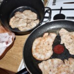 na dużej patelni smażą się kotlety schabowe oprószone mąką