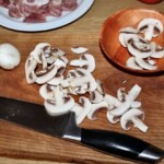 pokrojone w plastry pieczarki na desce kuchennej