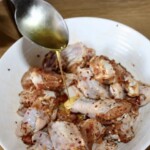 skrzydełka z kurczaka znajdujące się w misce polewane są miodem