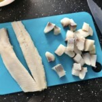 filet śledziowy krojony na desce kuchennej