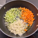 drobno pokrojone marchewka, cebula i seler naciowy do sosu bolognese (soffritto)smaży się na patelni