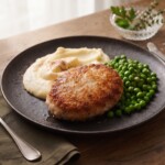 sznycel maślany podany z puree ziemniaczanym i groszkiem zielonym