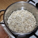 biała fasolka namacza się w dużym garnku z wodą