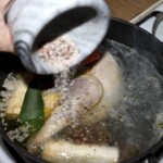 dodawanie przypraw z moździerza do garnka z zupą