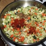 w garnku smażą się drobno pokrojone warzywa