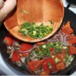 na patelni smaży się pokrojona w kostkę czerwona papryka oraz cebula