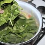 świeży szpinak wkładany jest do garnka z biała fasolką