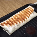 burrito z kurczakiem awokado i serem smaży się na patelni grillowej