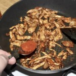 n patelni smaży się mięso z kurczaka w przyprawach