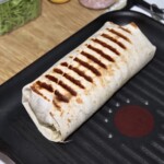 burrito z tuńczykiem i warzywami podgrzewane jest na patelni grillowej