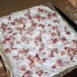 Flammkuchen alzacki podpłomyk z boczkiem przed pieczeniem
