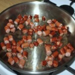 na patelni smażą się plasterki kiełbasek frankfurterek