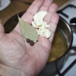 czosnek i liści laurowe na dłoni