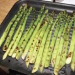 na patelni grillowej smażą się zielone szparagi