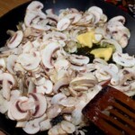 na patelni smażą się plasterki pieczarek i cebula