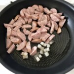 na patelni smażą się półplasterki kiełbasy