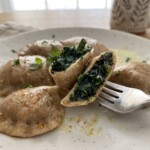 pierogi ze szpinakiem miętą i serem podane na talerzu