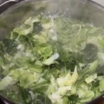 w garnku gotuje się siekana młoda kapusta