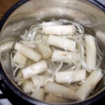 obrane i pokrojone białe szparagi gotują się w garnku