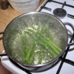 w garnku gotują się zielone szparagi
