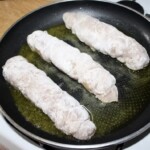 na patelni smażą się Roladki drobiowe z szynką szparagami i mozzarellą