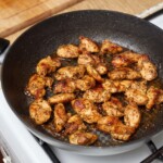 na patelni smaży się filet z kurczaka pokrojony małe kawałeczki