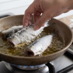 sardynki tuszki obtoczone w mące smażą się na patelni