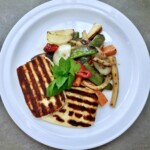 ser halloumi z warzywami smażonymi podany na talerzu