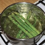 w garnku gotują się zielone szparagi